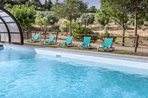 Una piscina cubierta, una piscina al aire libre, tumbonas
