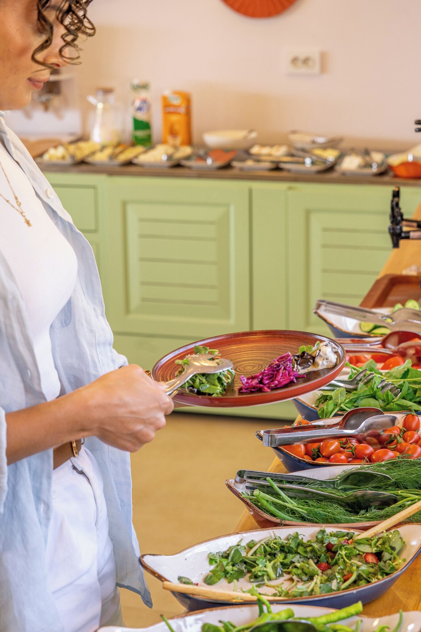 A buffet setup with various dishes and fresh vegetables.