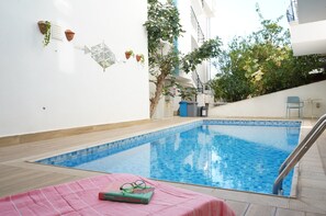 Een seizoensgebonden buitenzwembad en parasols bij het zwembad