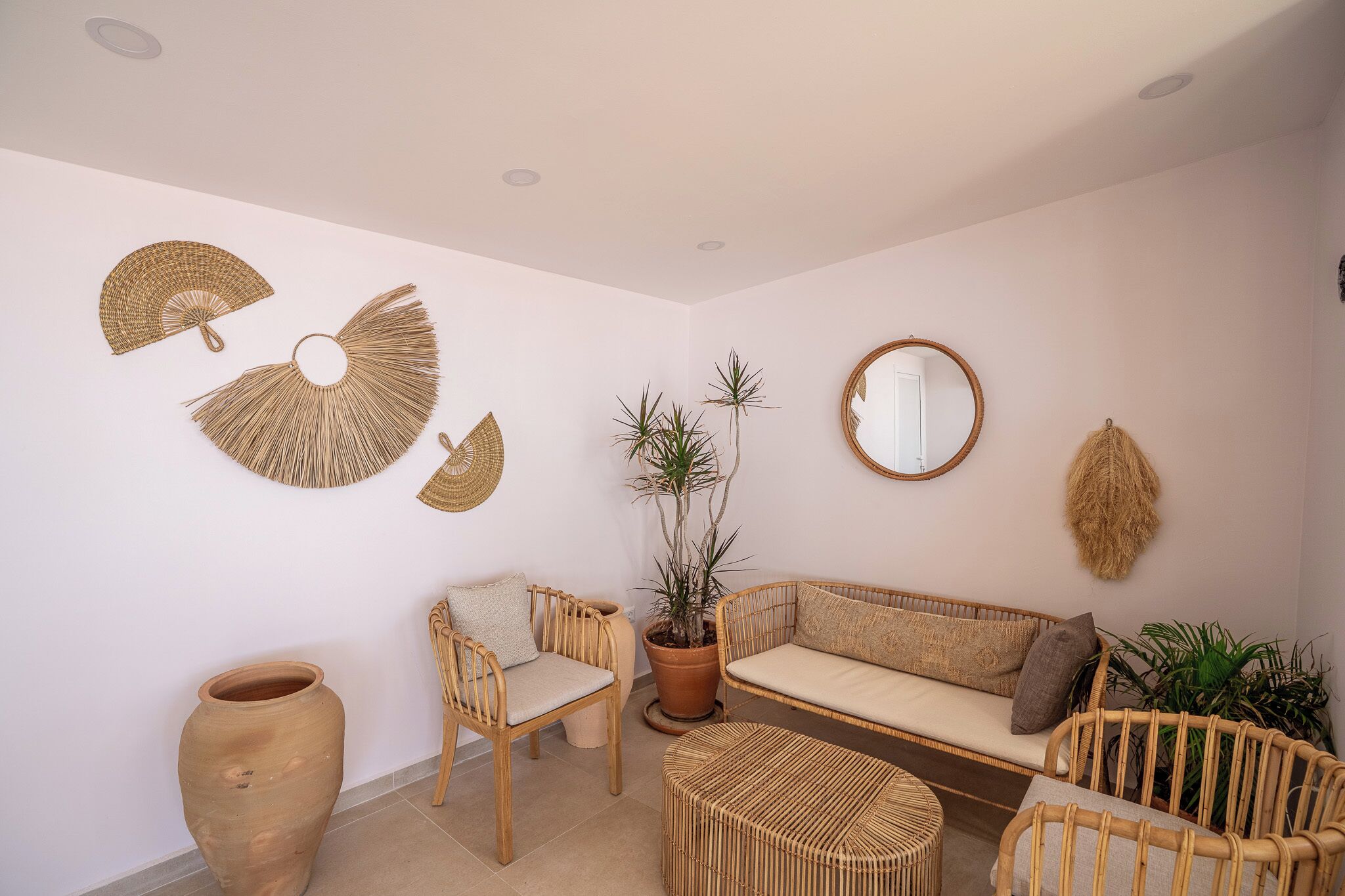 Una habitación con sofá, sillas, una mesa redonda y decoración en la pared.
