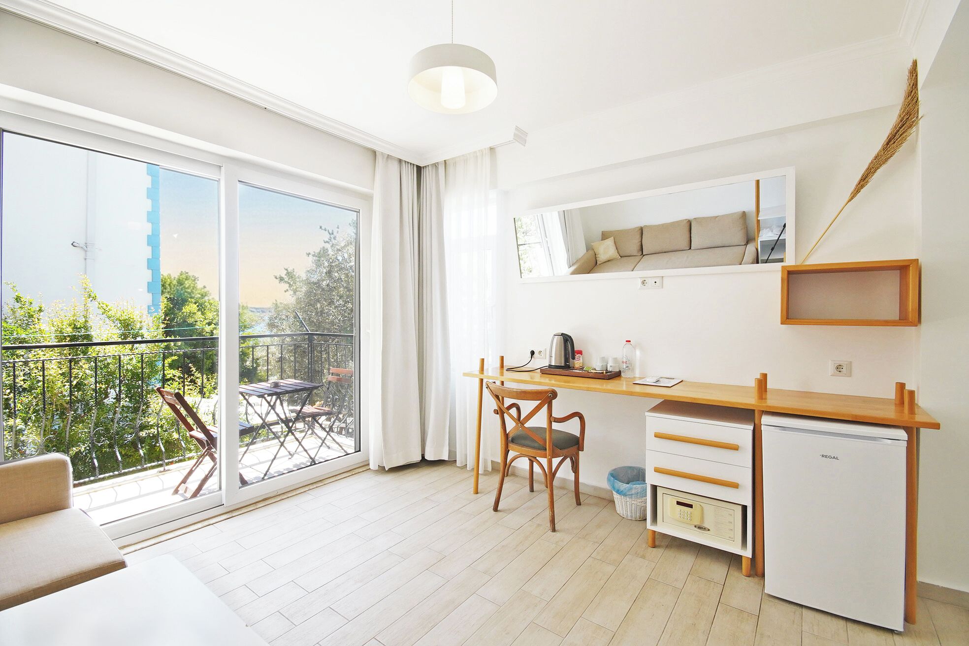 A modern kitchen with a dining area, a small refrigerator, and a view of the outdoors.