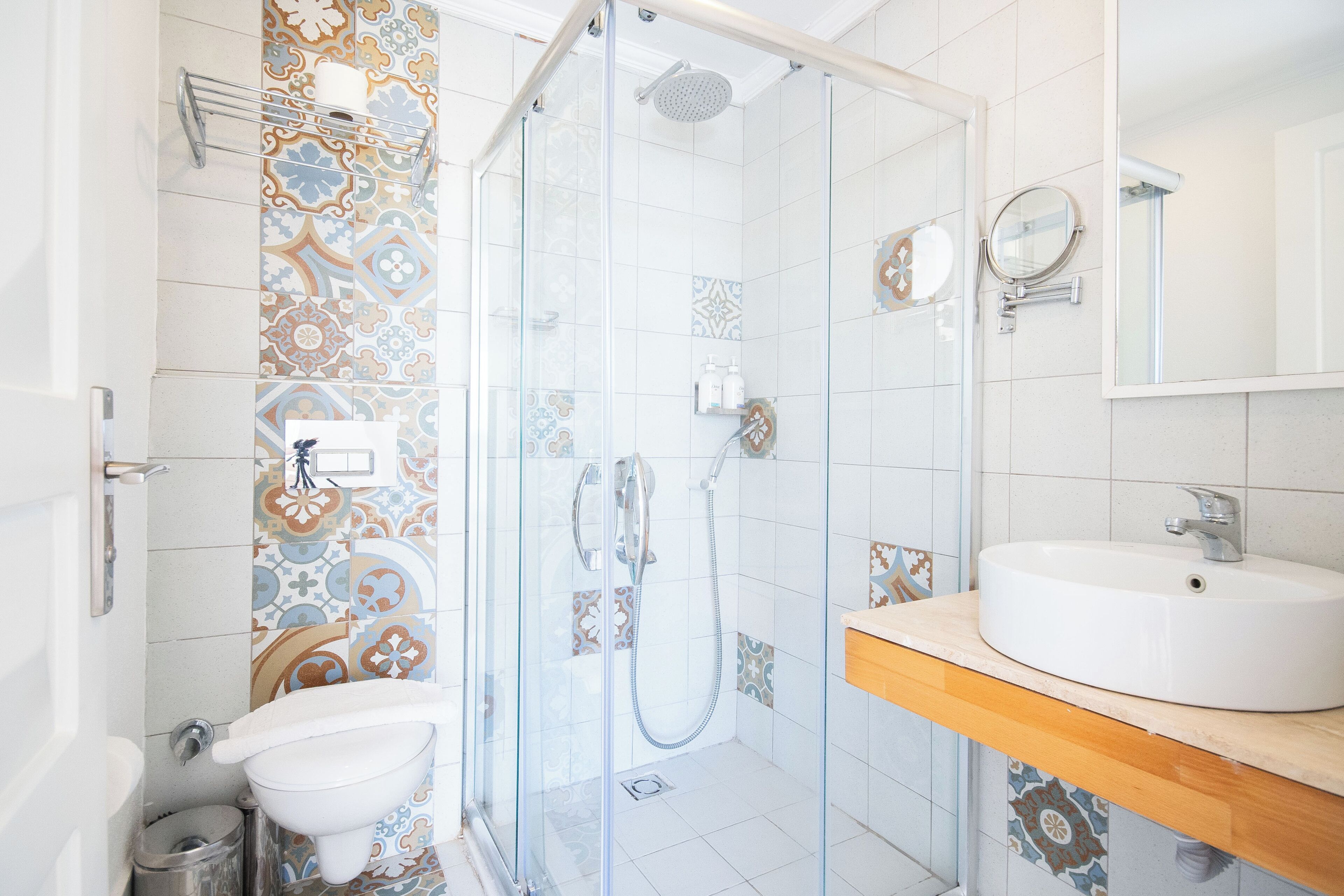 A bathroom with a glass-enclosed shower, a sink, and a mirror.