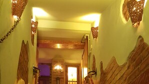 Una escalera con barandilla de madera y una cuerda de seguridad roja.