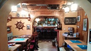 Un restaurante acogedor con decoración de madera, una zona de bar y temática náutica.