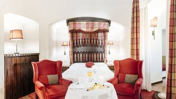 Un comedor con una mesa lista para dos, una pared decorativa y vista al salón.