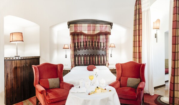 Un comedor con una mesa lista para dos, una pared decorativa y vista al salón.