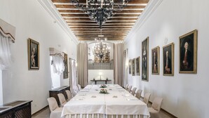 Un comedor formal con una larga mesa, sillas y una araña.