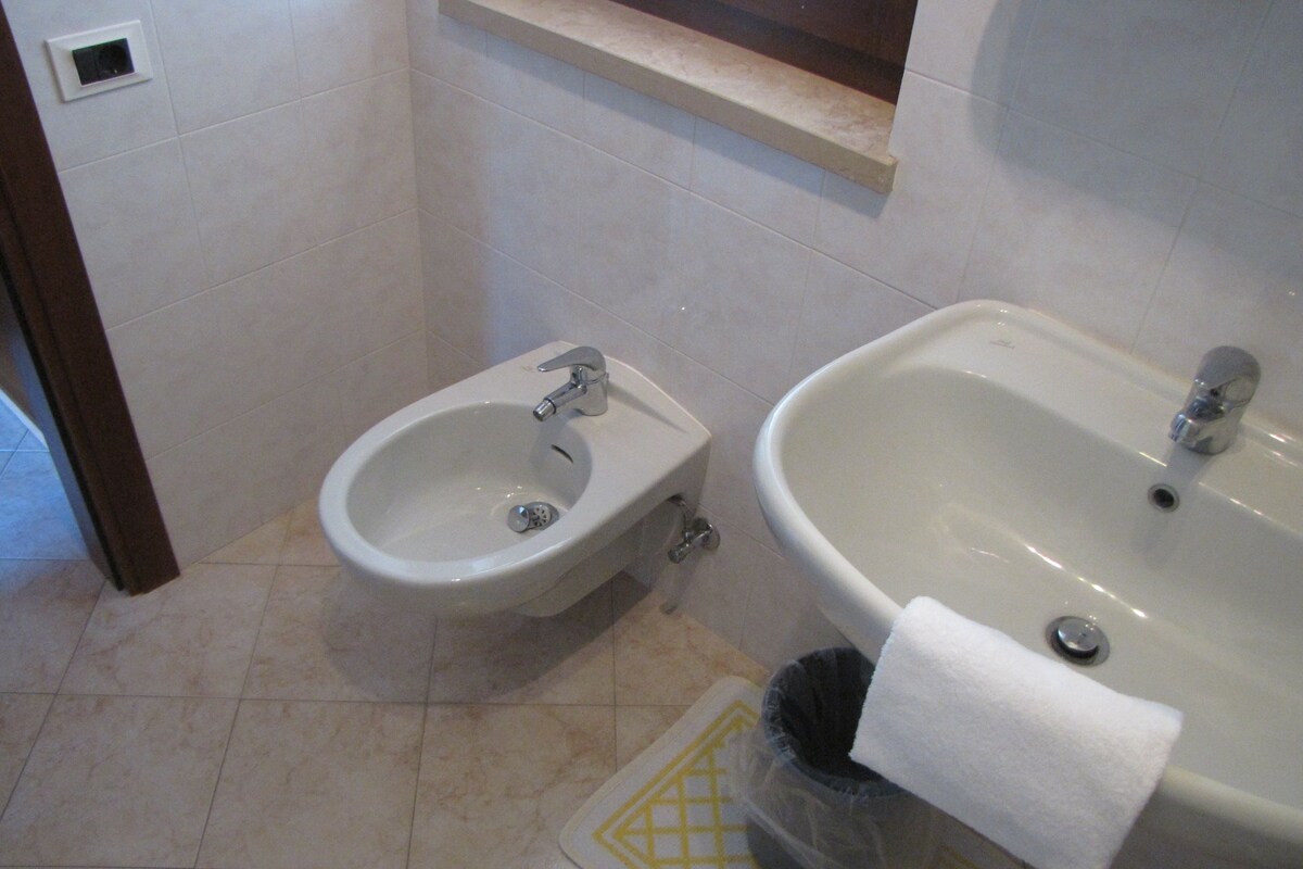 A bathroom with a bidet, a sink, and a toilet.