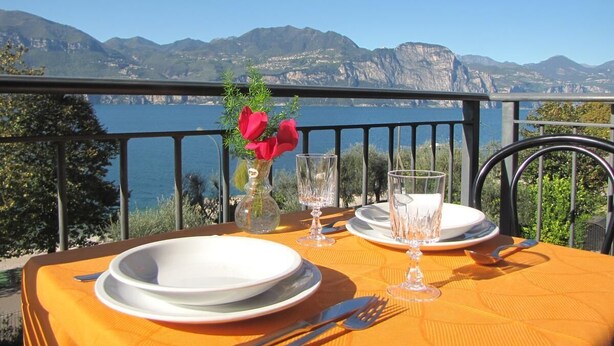 Mesa para dos con vistas a montañas y un cuerpo de agua.