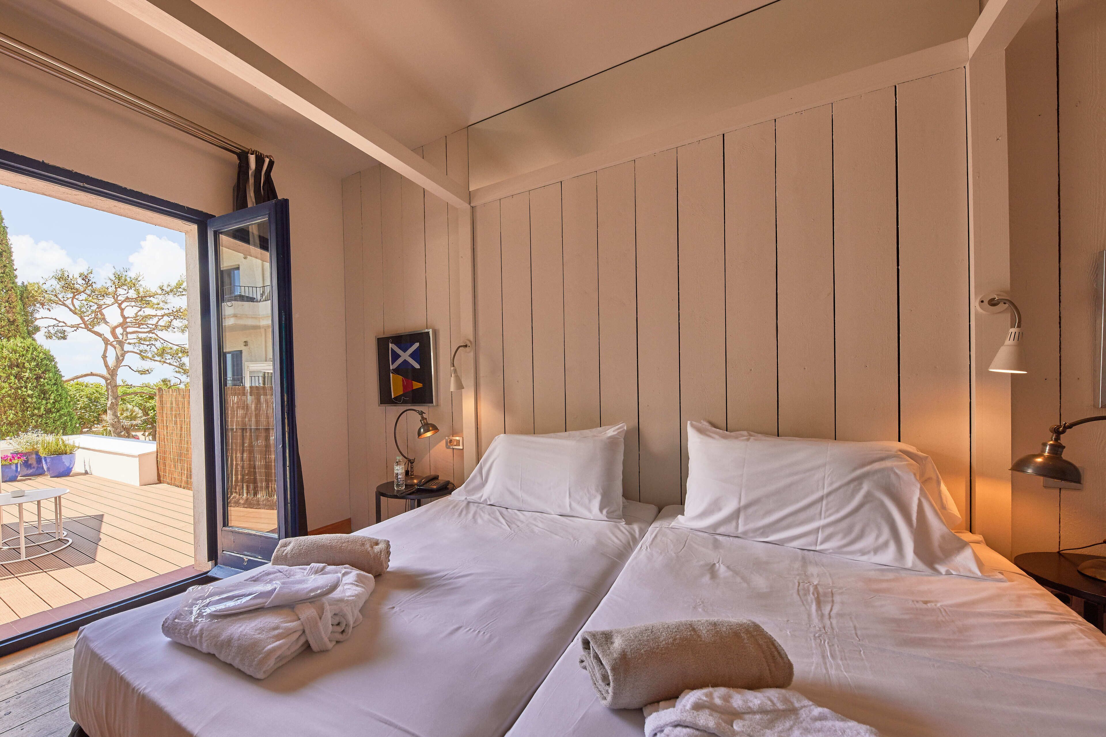 Une chambre double avec deux lits, une grande fenêtre et une vue sur l’extérieur.