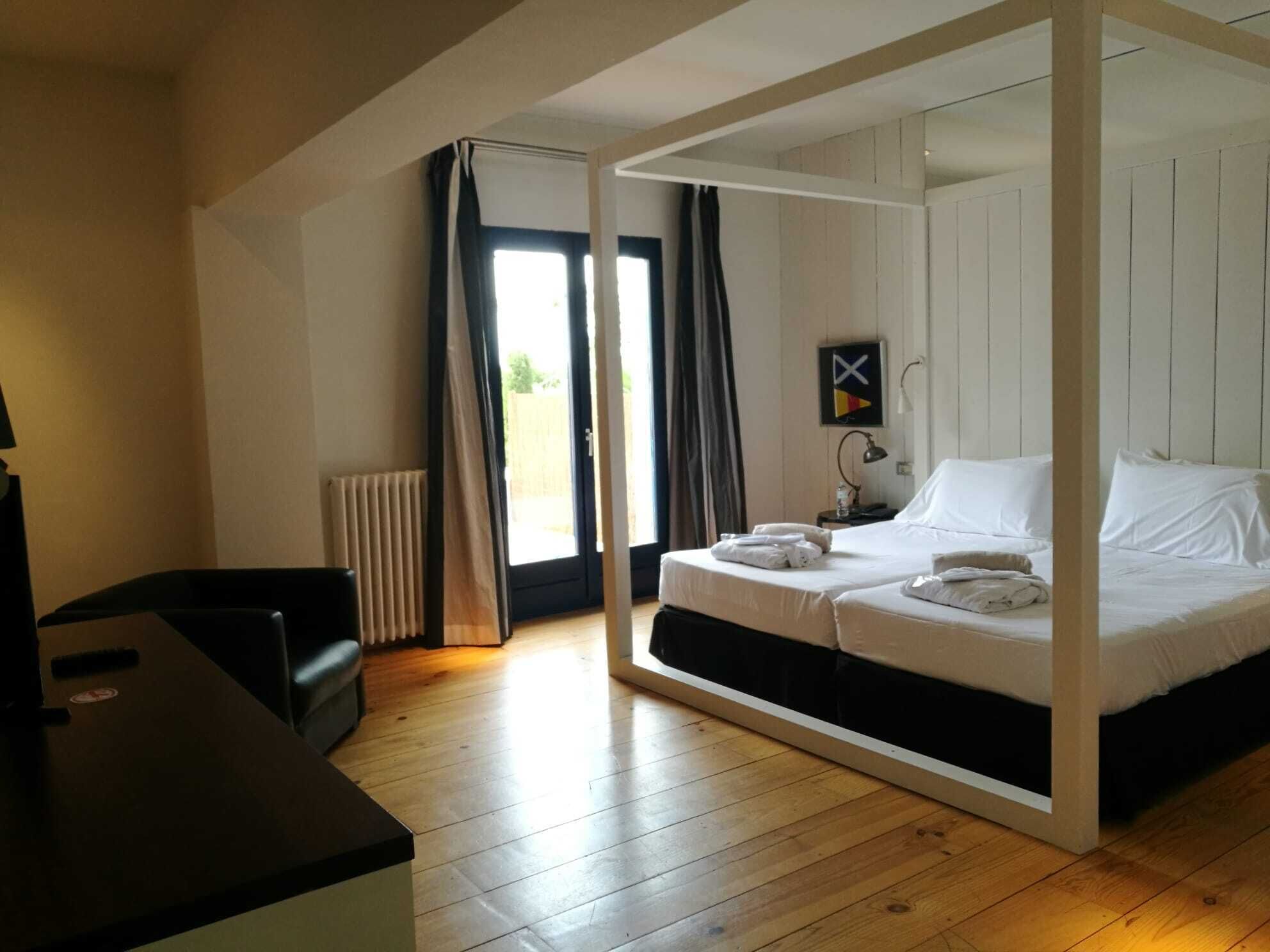 Un dormitorio moderno con dos camas, un escritorio y vistas al exterior.