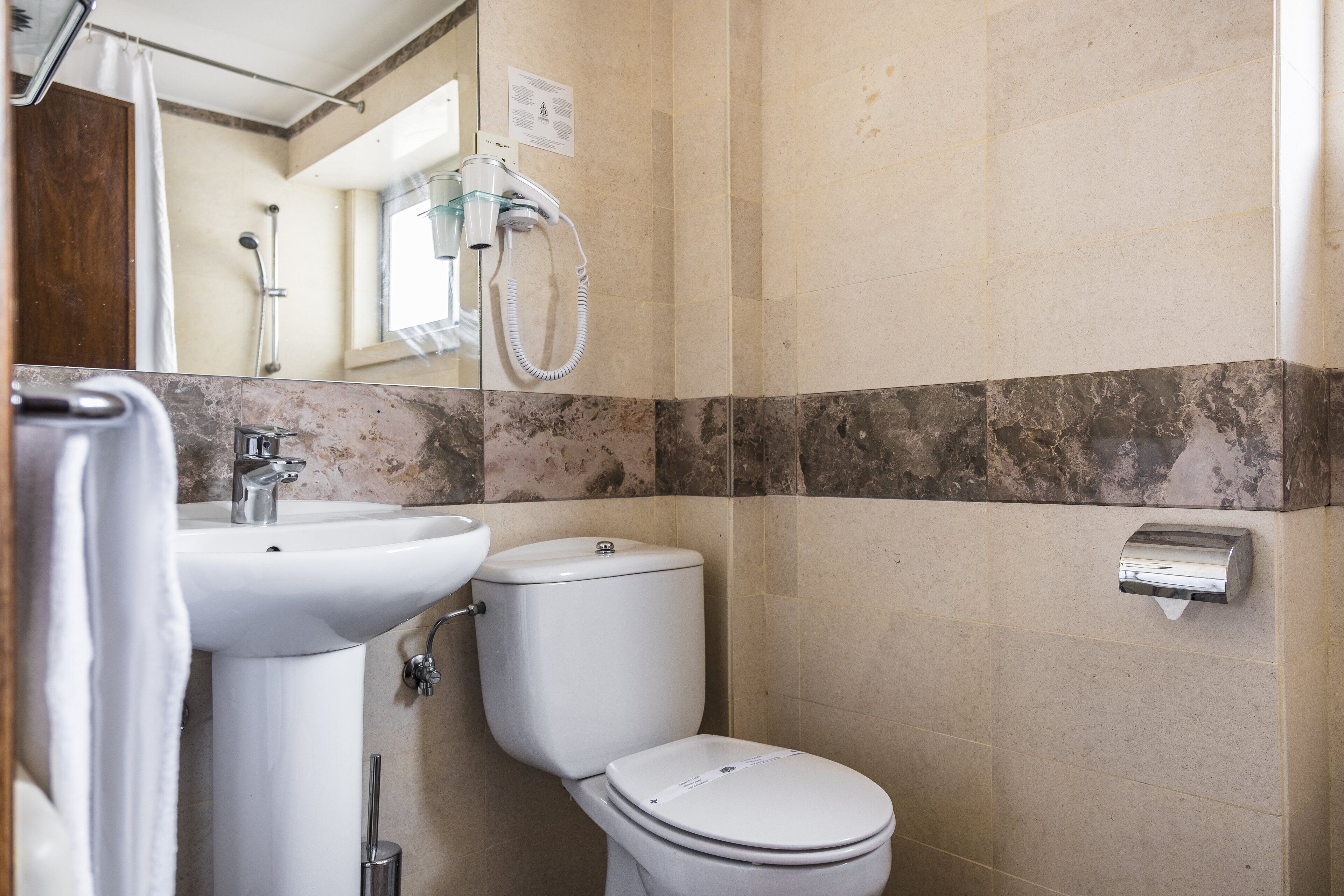Een badkamer met een wastafel, toilet en douche.