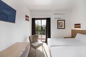 A hotel room with a bed, a chair, a desk, a window with a view, and a wall-mounted sign. - Crisol Tres Pastorinhos (Ourem)