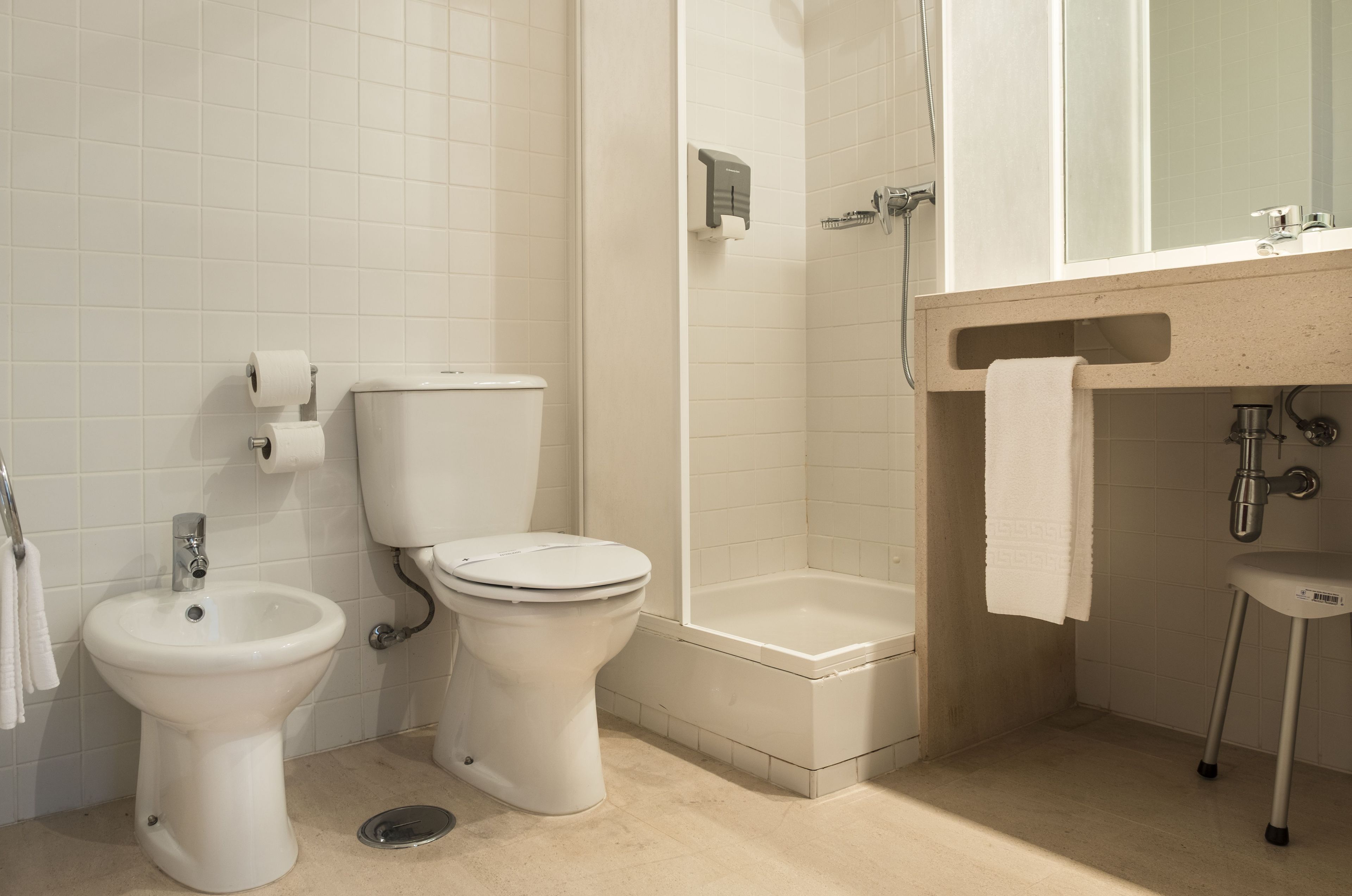 Une salle de bain équipée de toilettes, d’un bidet et d’une baignoire.