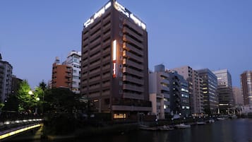 A high-rise hotel with multiple floors, a prominent sign at the top, and a waterfront view.