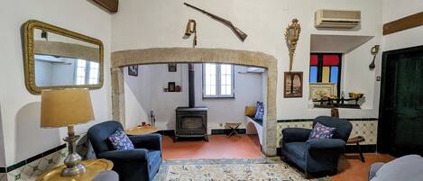 Una sala de estar acogedora con dos sofás, una chimenea, un espejo y una alfombra estampada.