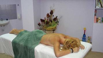 A room with a bed, a sink, and a shelf with items.