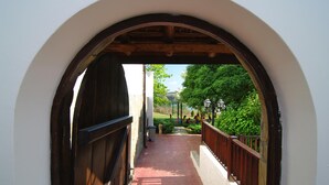 An arched corridor with a wooden door, a tiled pathway, and a railing. - Resort Bella Vista Beach Club (Sinemoretz)