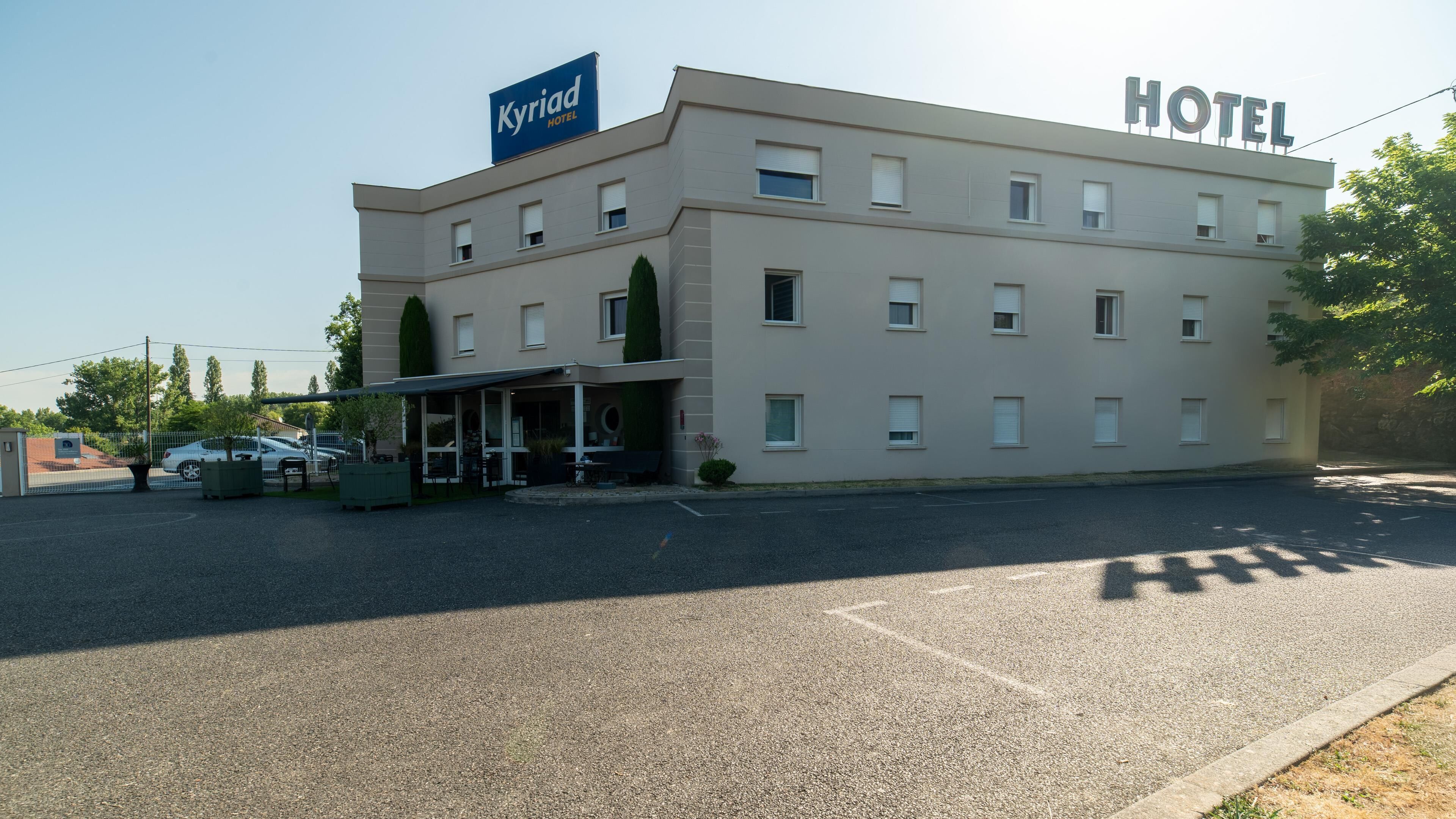 Un edificio de hotel con un cartel que dice 'Kyriad Hotel'.