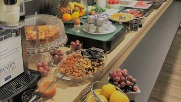 A buffet with various food items and a coffee machine.