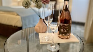 A bottle of Secco wine, two wine glasses, and a vase with flowers on a glass table in a hotel room. - Altdeutsche Weinstube (Ruedesheim am Rhein)