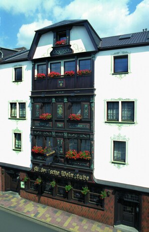 A traditional European building with multiple windows and flower boxes.