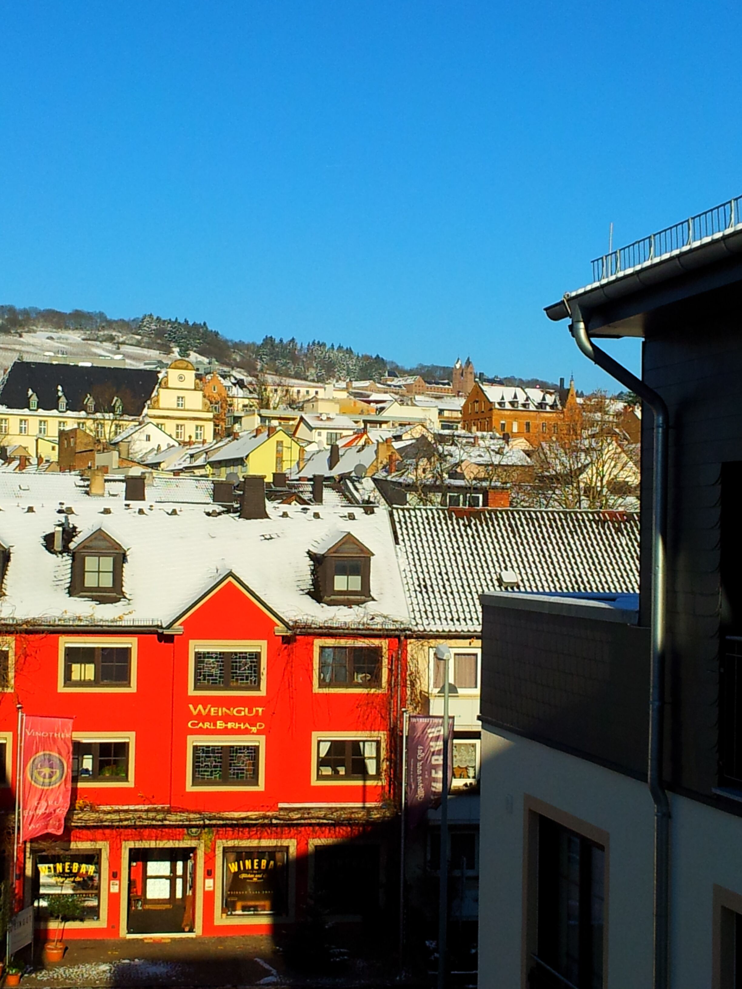 A red building with a sign that reads "WEINGUT CARLBERHOF" and a flag.