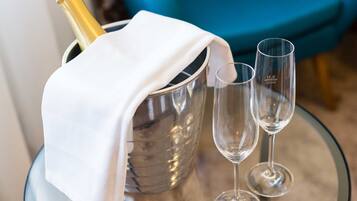 A glass table with a champagne bottle and two glasses.