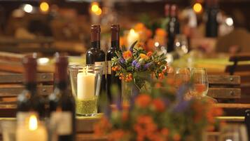 A table set with candles, wine bottles, and a floral centerpiece.