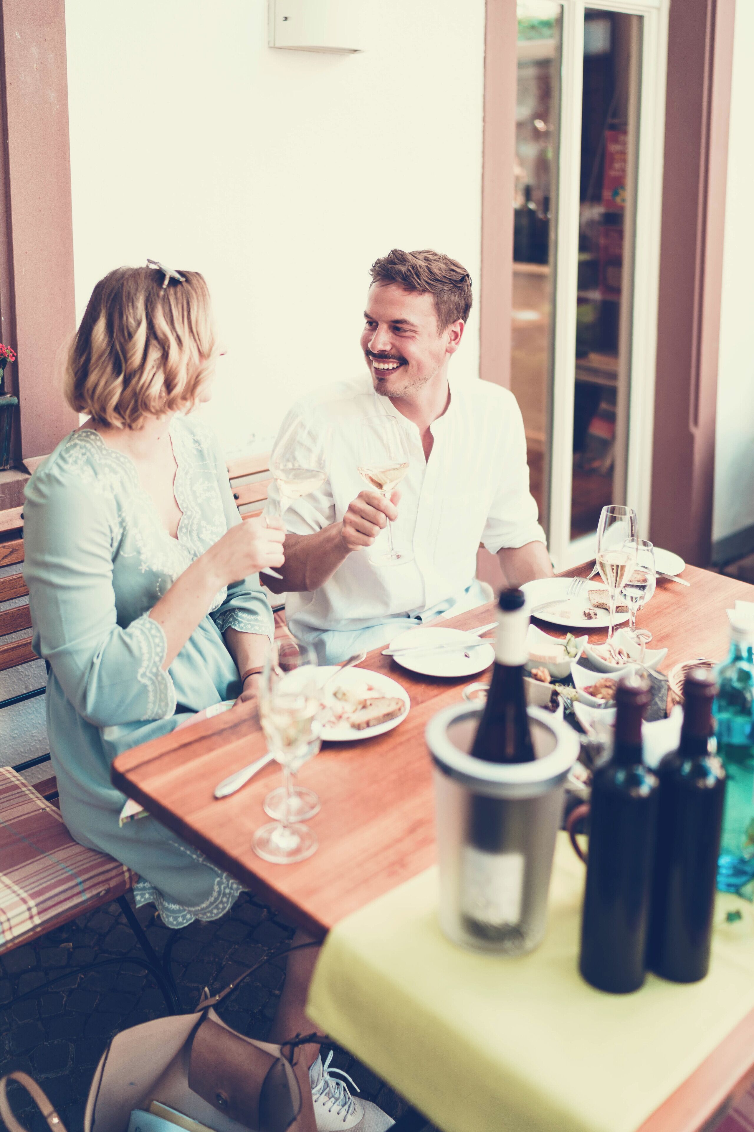 Una mesa de comedor con platos, vasos y botellas, indicando un ambiente para comer.