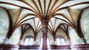Interior de una catedral con techos abovedados altos y ventanas en arco.