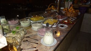 A buffet with various food items and condiments. - Apparthotel Alte Innbruecke (Neuhaus am Inn)