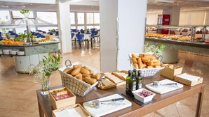 Mesa de buffet con pan, pastelería y salsas.