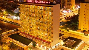 Un hotel de varios pisos con un letrero llamativo que dice "HOTEL GANDIA".