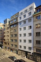 En bygning med flere etager i moderne arkitektur, med et mix af vinduesdesigns og balkoner.