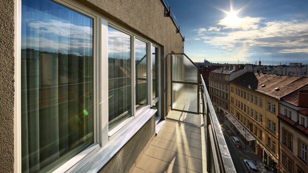 Un balcón con ventanas amplias que dan a una vista panorámica de la ciudad.