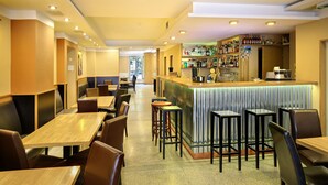 Un restaurante con varias mesas y sillas, una zona de bar con mostrador y taburetes, y vistas de la calle a través de un ventanal grande.