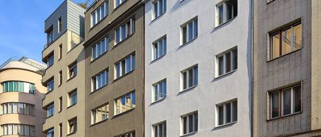 Un edificio de varios pisos con un diseño moderno, que combina diferentes estilos de ventanas y una fachada plana.