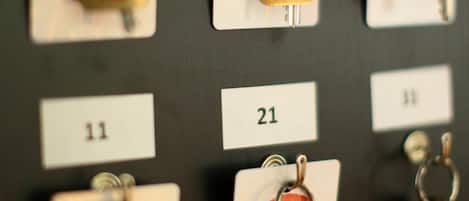 Un mostrador con llaves etiquetadas con números, probablemente de un hotel u otro establecimiento similar.