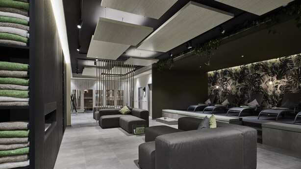 Un espacio lounge moderno con sofás y una barra.
