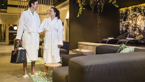 Un moderno vestíbulo de hotel con mostrador de recepción, zona de estar y sala de masajes.