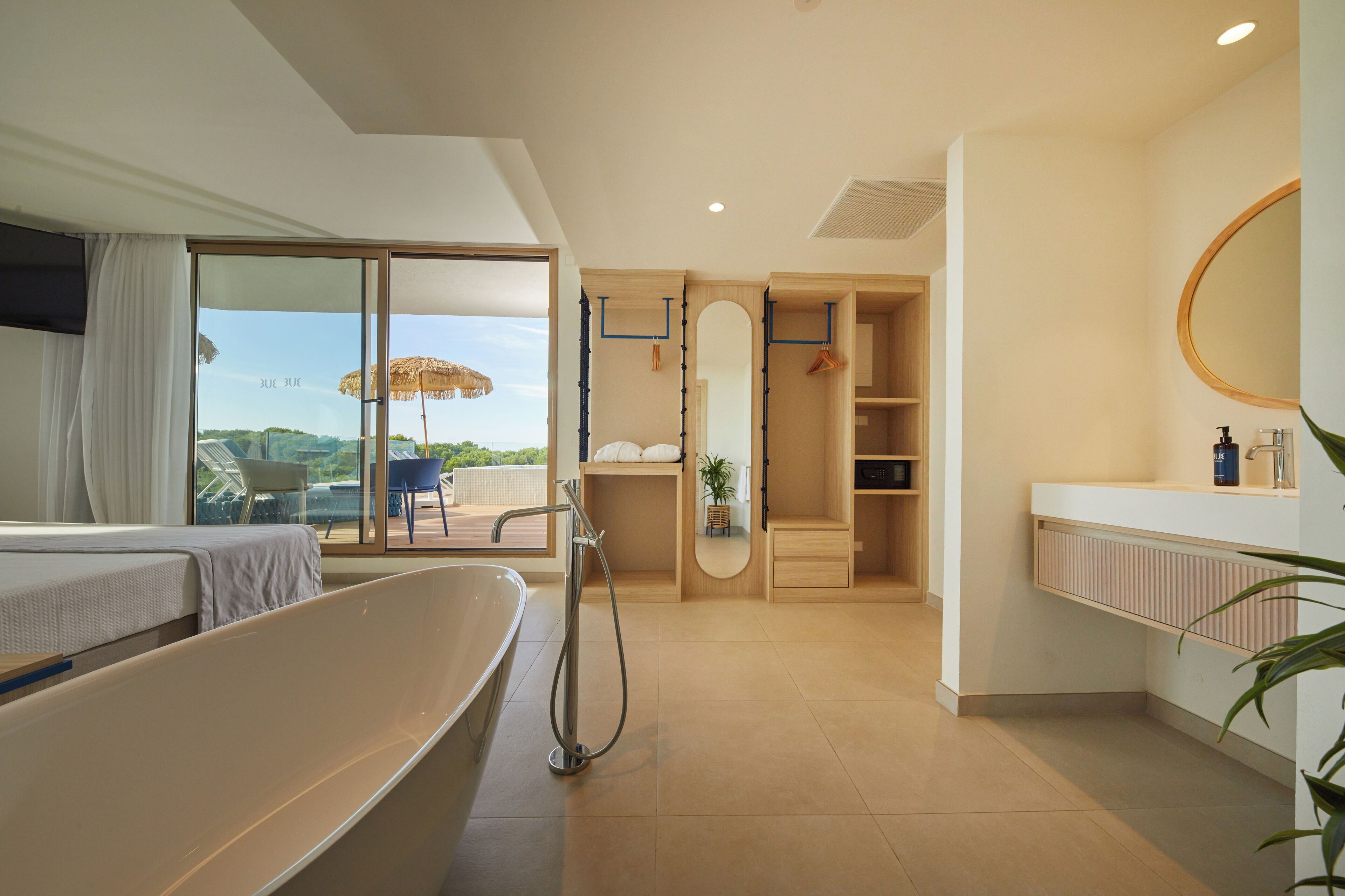 A modern bathroom with a bathtub, shower, and a large mirror.