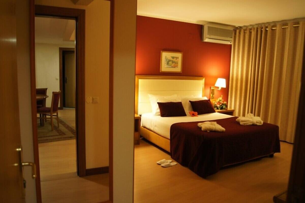 Une chambre d’hôtel avec un lit, une table de chevet, une lampe et un tableau au mur.