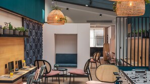 Et moderne loungeområde med siddepladser, borde og et bordfodboldspil.