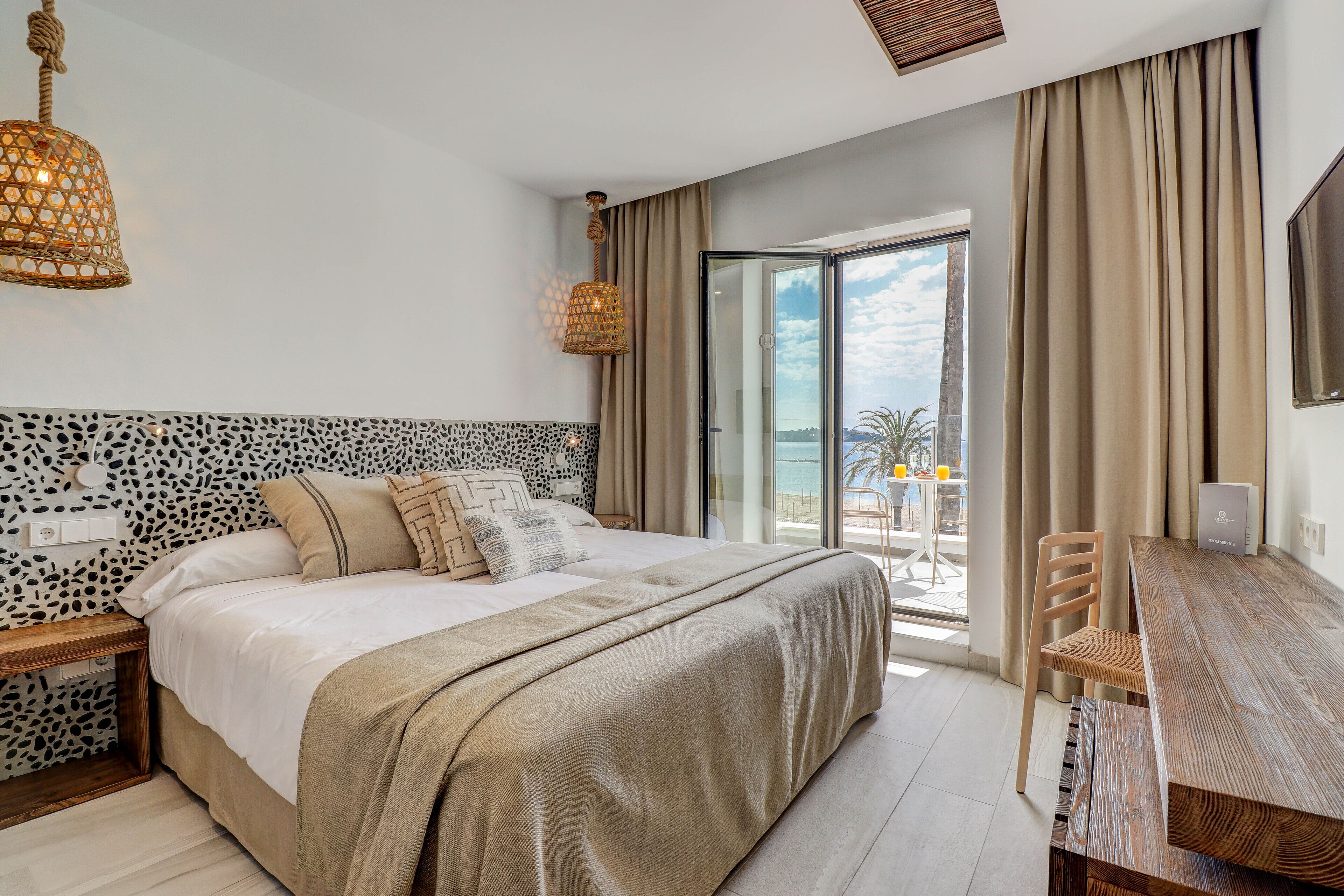 أسرّة بطبقة علوية مريحة وميني بار وخزنة داخل الغرفة ومكتب