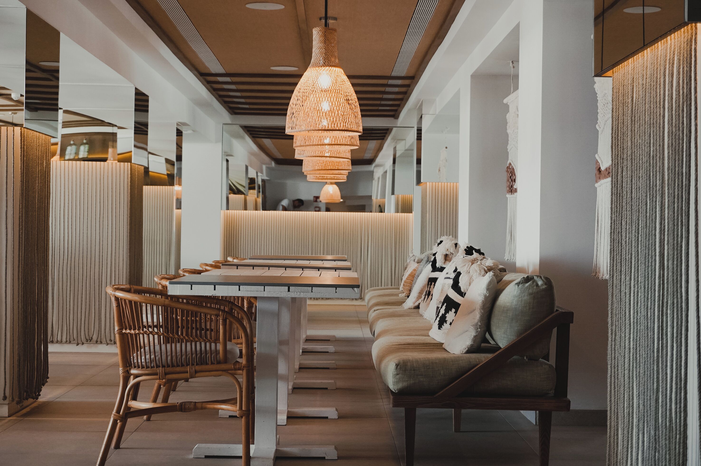 Un intérieur moderne avec une table centrale, un coin salon et un luminaire suspendu.