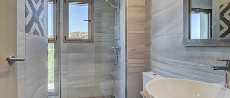 Une salle de bain moderne équipée d’une douche, de toilettes et d’un lavabo.