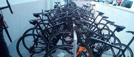 A row of bicycles parked in a lot, with a person walking by.