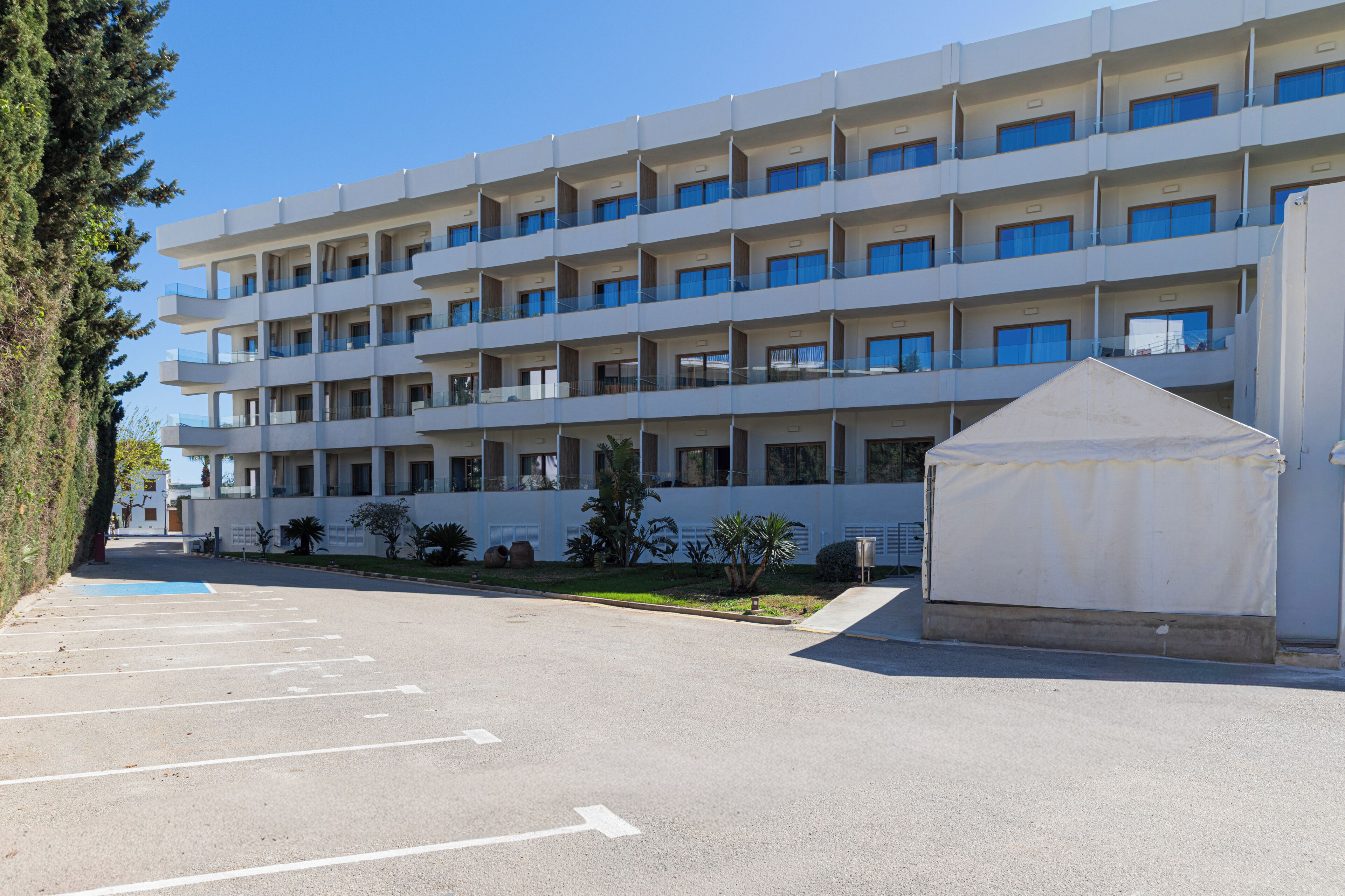 Un hotel de diverses plantes amb aparcament i zona coberta.