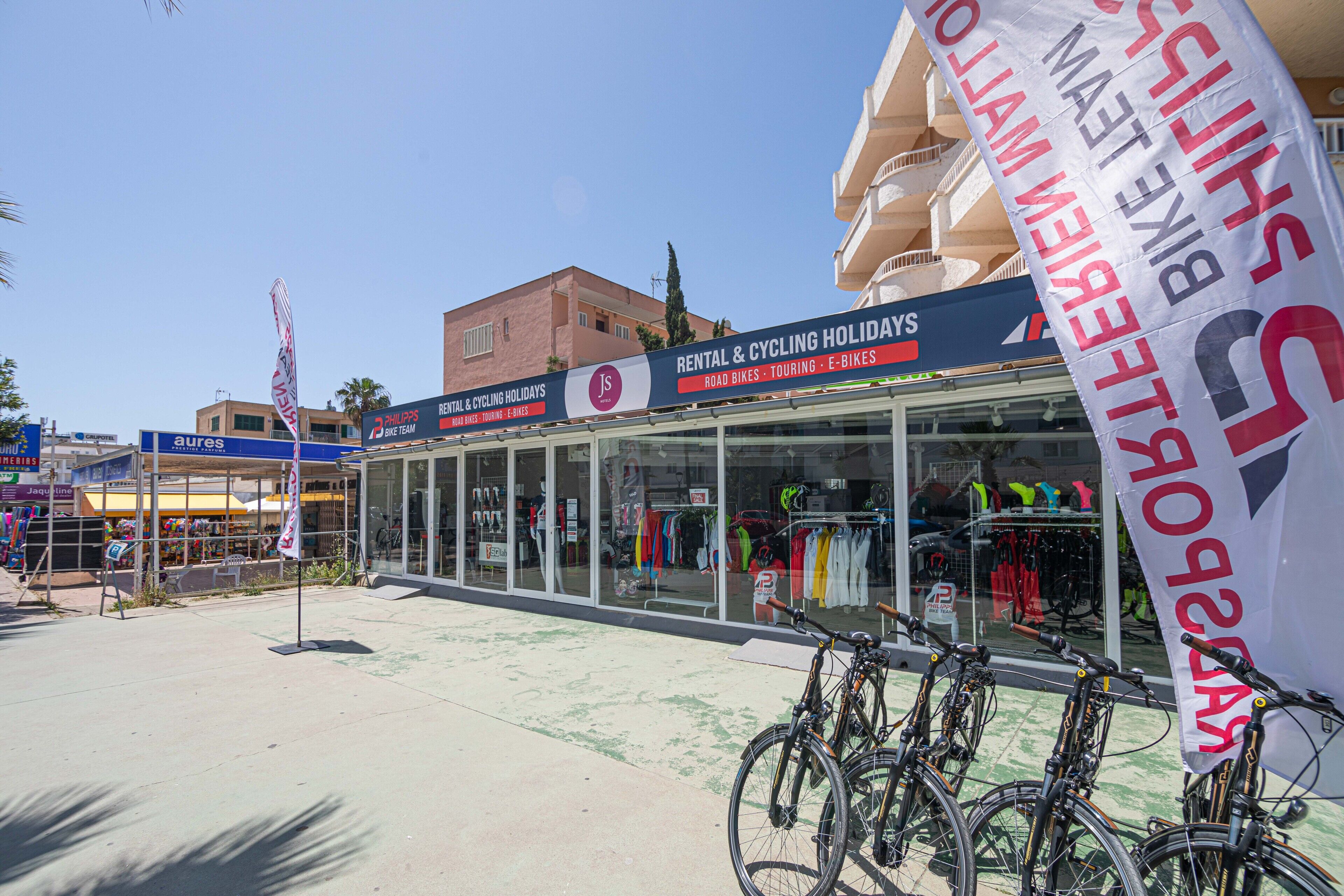 Ein Schaufenster mit Schild für Mietangebote und Radurlaub, darunter Rennräder und Trekking-E-Bikes.